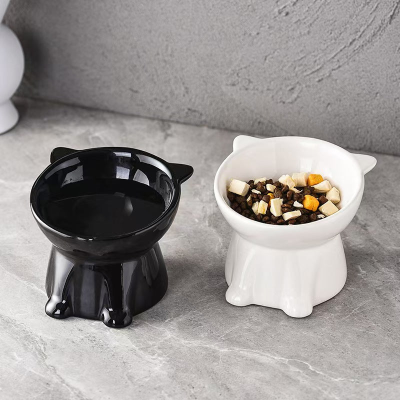 Black and white raised cat bowls on a grey surface